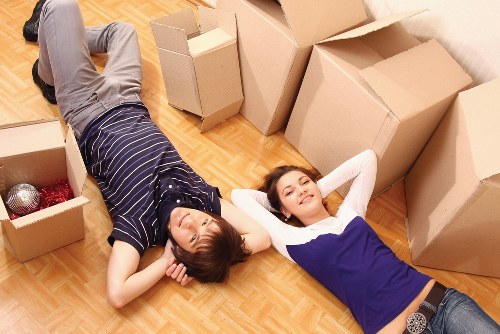 Workers handling packed boxes with careful lifting technique